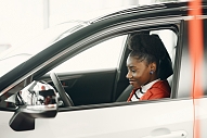 Teenage girl in driver seat of sedan.